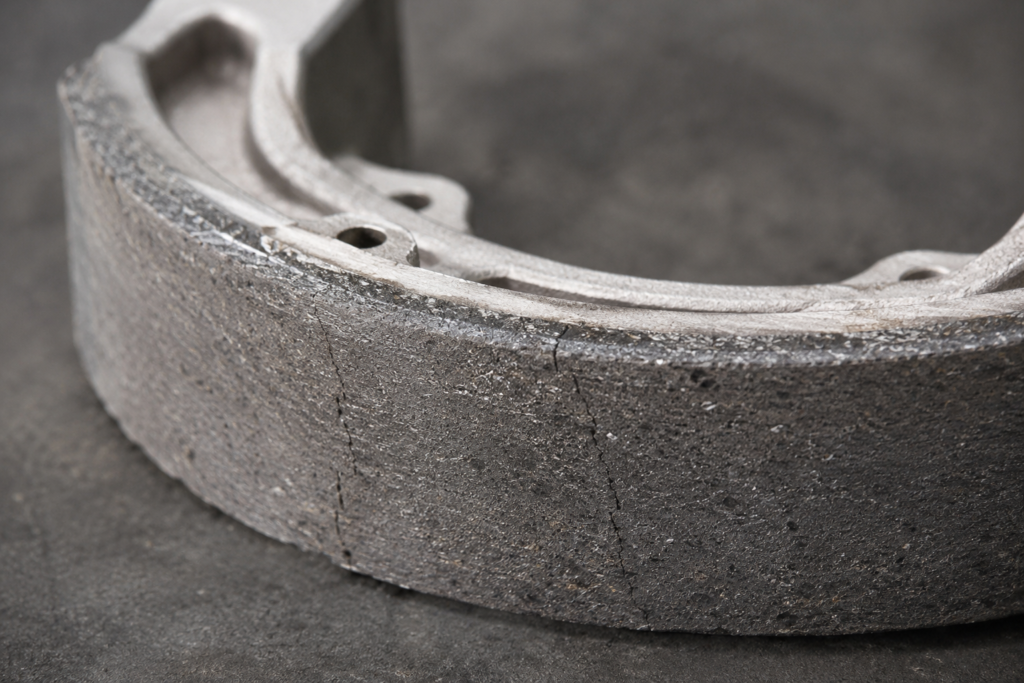 Motorcycle brake shoe showing cracks in the friction lining